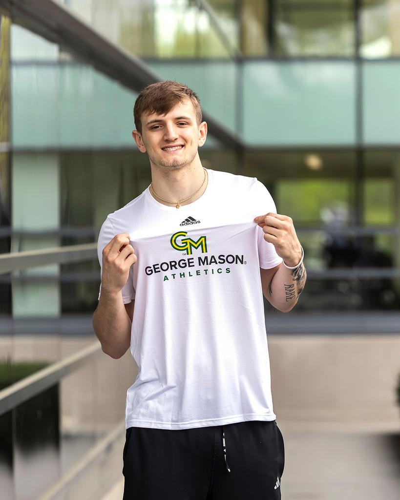 A student wears a white shirt with the George Mason Athletics logo.