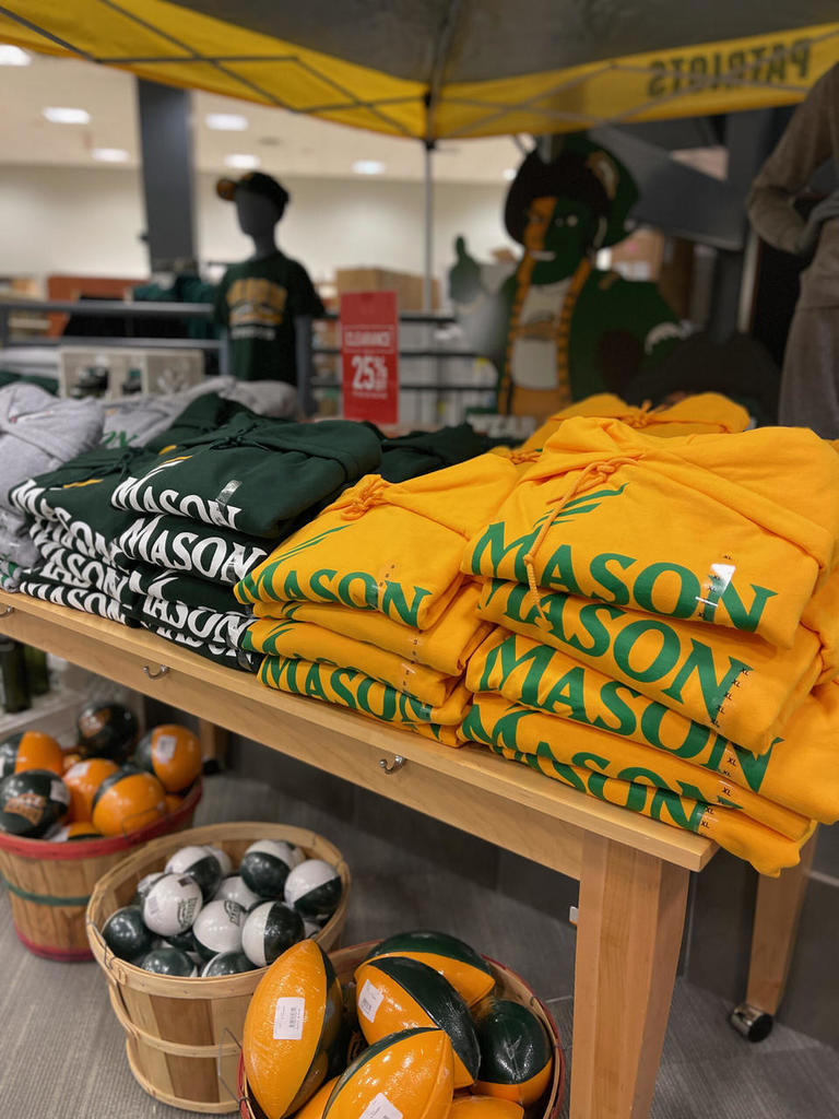 Sweatshirts with the George Mason University logo on a table at the Mason Bookstore.